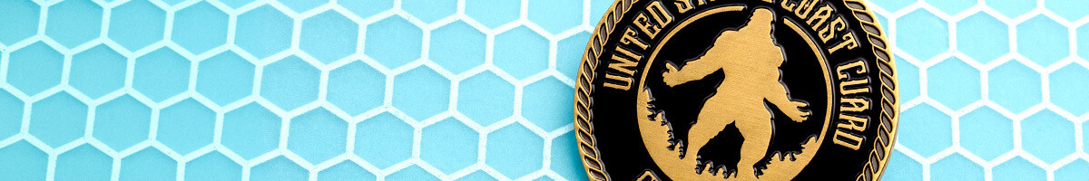United States Coast Guard challenge coin with a gold Sasquatch silhouette cut into black enamel