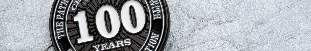 Black nickel centennial coin reading "the path to greatness is paved with sacrifice and dedication"