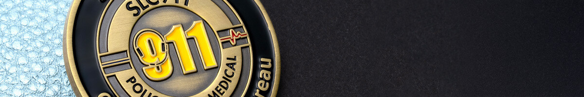 Close-up of the reverse of a Salt Lake City 911 coin showing the communications bureau's gold 911 mark with a heartbeat line