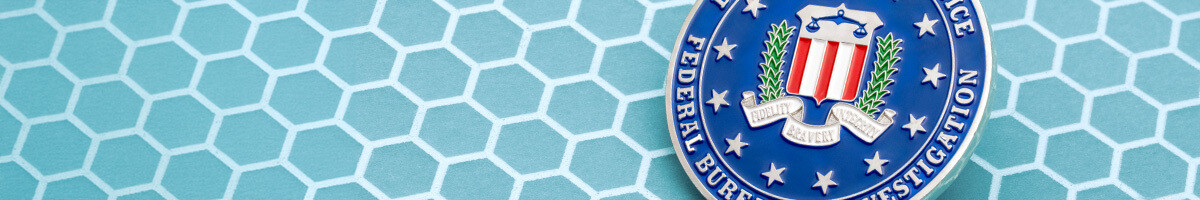 Close-up of a challenge coin carrying the authentic FBI seal with the Fidelity Bravery Integrity motto in blue enamel