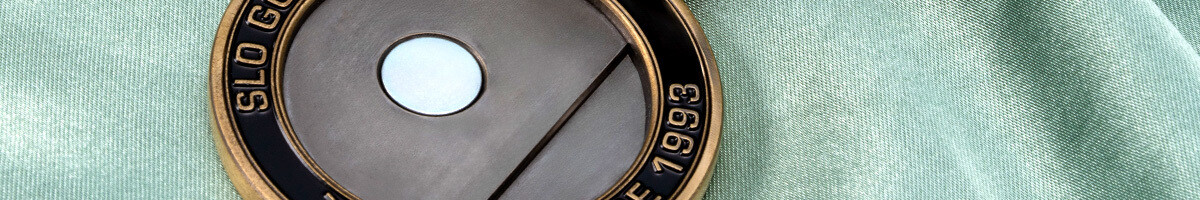 Close-up of an antique gold golf coin holder with the magnet that seats the ball marker