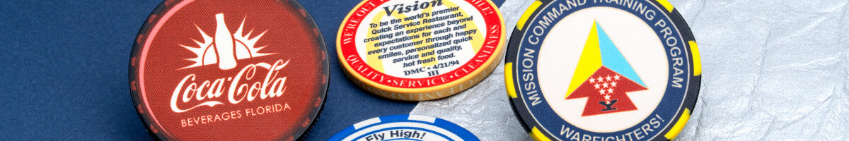 Four branded ceramic poker chips including corporate, restaurant, and military designs
