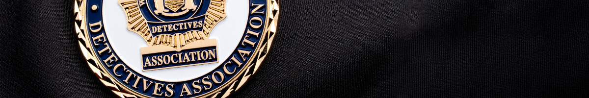 Gold and navy Detectives Association challenge coin in close-up