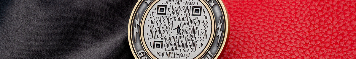 Close crop of an antique silver QR code coin with a figure worked into the code pattern