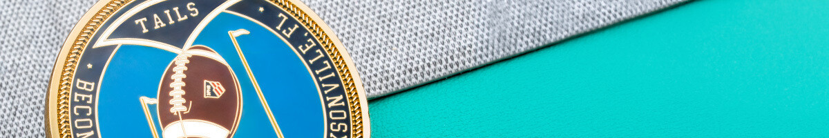 Close-up of a blue and gold football officials coin marked tails