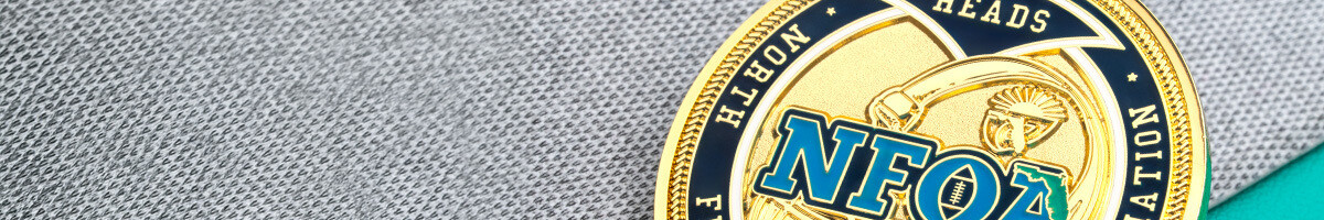 Close-up of a gold football officials association coin marked heads