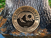 Brave Wilderness Display Coin Against Tree