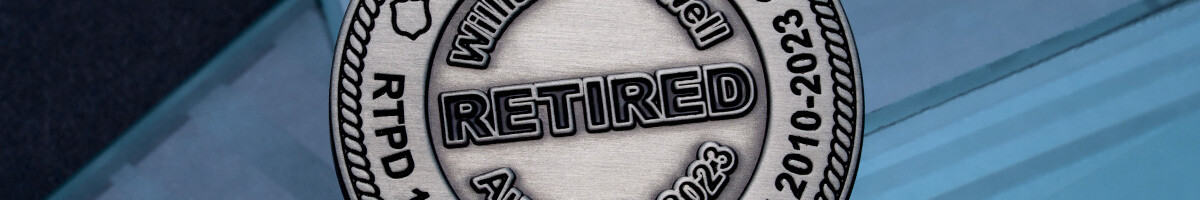 Antique silver law enforcement retirement coin engraved with the officer's service dates